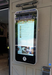 Add Vision wall-mounted PCAP outdoor touch screen display showing user interface in a rugged outdoor setting.
